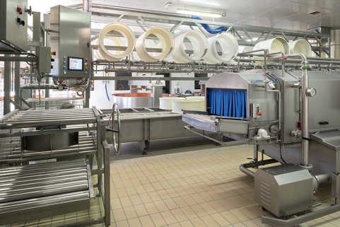 Atelier de fabrication : système de transfert des moules à gauche (avec le tableau de commande du pressage), extrémité du tunnel de lavage à droite. © Région Bourgogne-Franche-Comté, Inventaire du patrimoine