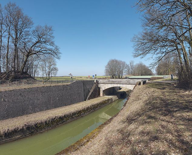 Le pont en pierre de l'amont, avec un des deux escaliers d'accès à la banquette de halage de la tranchée. Derrière le pont plus récent. © Région Bourgogne-Franche-Comté, Inventaire du patrimoine
