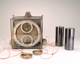 L'horloge dans sa cage vitrée, avec ses deux poids cylindriques à poulie. © Région Bourgogne-Franche-Comté, Inventaire du patrimoine