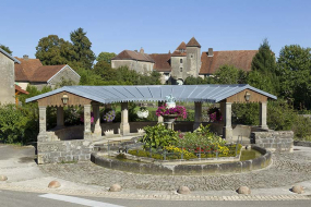 La fontaine sur la place principale du village, et la maison forte en arrière plan. © Région Bourgogne-Franche-Comté, Inventaire du patrimoine