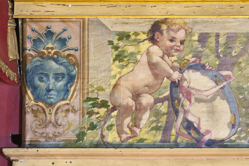 Détail de la frise supérieure de la peinture monumentale de Vernon : masque et enfant jouant avec un tambourin, théâtre municipal, Nevers (58) © phot. P.-M. Barbe-Richaud, Région Bourgogne-Franche-Comté, Inventaire du patrimoine, 2025