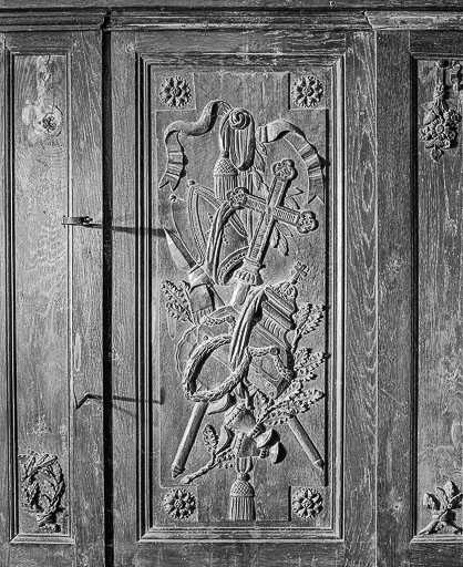 Lambris du choeur : côté gauche, 2e travée, 3e panneau, chute d'instruments liturgiques. © Yves Sancey / Région Bourgogne-Franche-Comté, Inventaire du patrimoine - 1976