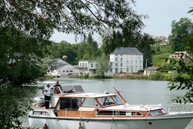 Les bâtiments modernes du moulin vus d'amont. Bateau de plaisance au premier plan. © Région Bourgogne-Franche-Comté, Inventaire du patrimoine