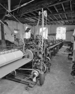 Système moteur : partie arrière vue de la gauche. Les mouvements du chariot sont commandés par la poulie à gorge de forme spéciale (dite scroll) sur laquelle s'enroule la corde. © Région Bourgogne-Franche-Comté, Inventaire du patrimoine