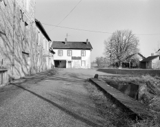 Vue depuis l'entrée.De gauche à droite : atelier de fabrication, logement patronal et parties agricoles, logement d'ouvriers, remise à automobile. © Région Bourgogne-Franche-Comté, Inventaire du patrimoine