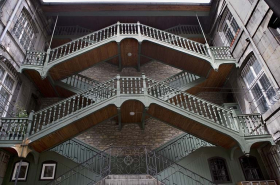 Escalier à cage ouverte à droite de la première cour : vue d'ensemble, de face, des volées suspendues en charpente. © Région Bourgogne-Franche-Comté, Inventaire du patrimoine