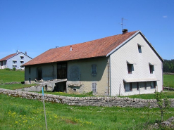 Vue de trois quarts du pignon sud-ouest et de la façade postérieure avec pont de grange. © Région Bourgogne-Franche-Comté, Inventaire du patrimoine