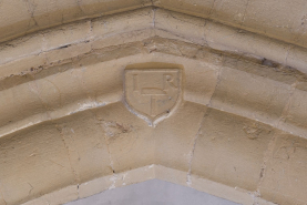 Arc brisé à la jonction de la nef et du transept : écu portant les initials I R et un marteau de sculpteur. © Région Bourgogne-Franche-Comté, Inventaire du patrimoine