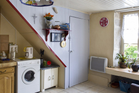 Intérieur : la cuisine en direction de l'entrée (porte donnant accès à l'escalier conduisant à l'étage des chambres ; emplacement de l'ancien évier devant la fenêtre). © Région Bourgogne-Franche-Comté, Inventaire du patrimoine