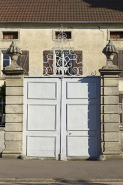 Porte flamande à couronnement de fer forgé, et deux vases d'amortissement sommant ses deux piliers. © Région Bourgogne-Franche-Comté, Inventaire du patrimoine