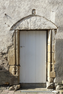 Ferme à l'ouest de l'ancienne cure (parcelles cadastrées D 562 et 446) : tympan en plein cintre décoré d’oiseaux et de feuillages en relief écrasé remployé comme linteau d'une porte aux piédroits moulurés. © Région Bourgogne-Franche-Comté, Inventaire du patrimoine