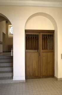 Aile droite dite "le grand corps de logis" : première volée de l'escalier (accès au rez-de-chaussée surélevé) et porte d'accès à la descente de cave. © Région Bourgogne-Franche-Comté, Inventaire du patrimoine