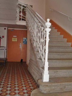 Vue intérieure, escalier en fonte au départ du rez-de-chaussée et carrelage en ciment. © Région Bourgogne-Franche-Comté, Inventaire du patrimoine