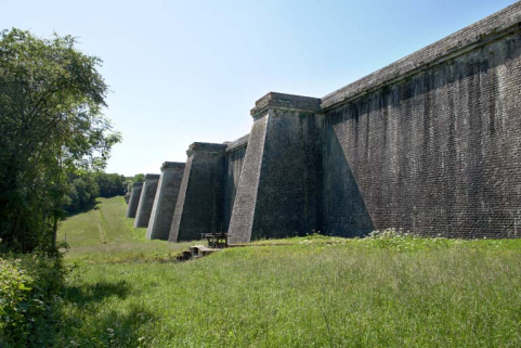 Face avant du barrage, vue de l'extrémité nord. La rigole d'alimentation au premier plan. © Région Bourgogne-Franche-Comté, Inventaire du patrimoine