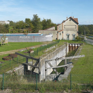 De gauche à droite, la péniche-salle d'exposition du Musée du Canal, la boulangerie de la cité Perrusson dans l'axe de l'ancien tracé du canal. © Région Bourgogne-Franche-Comté, Inventaire du patrimoine