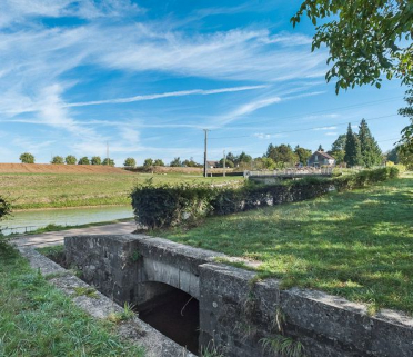 Détail de la maçonnerie de l'ancienne prise d'eau dans la rigole. Ecluse en arrière-plan. © Région Bourgogne-Franche-Comté, Inventaire du patrimoine