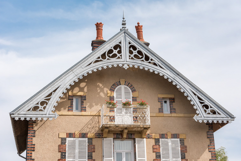 Pignon protégé par une large saillie de rive décorée d'un lambrequin métallique découpé. © Région Bourgogne-Franche-Comté, Inventaire du patrimoine Pignon protégé par une large saillie de rive décorée d'un lambrequin métallique découpé. © Région Bourgogne-Franche-Comté, Inventaire du patrimoine