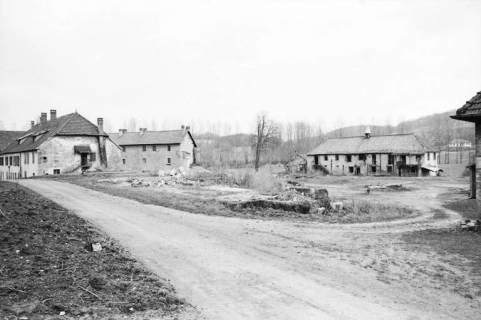 Vue d'ensemble en 1979.De gauche à droite : logement patronal, logement d'ouvriers et presbytère. Au premier plan, vestiges des ateliers de fabrication. © Région Bourgogne-Franche-Comté, Inventaire du patrimoine
