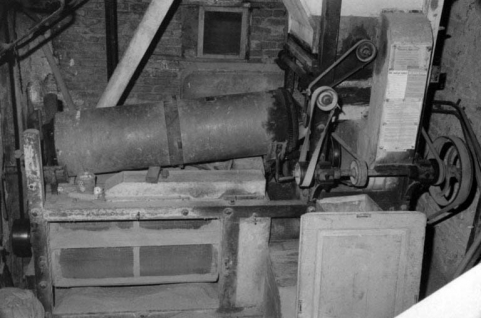 Intérieur : rez-de-chaussée, cage d'escalier, nettoyage combiné. Trémie d'alimentation à droite, cylindre trieur et décortiqueur au centre. © Région Bourgogne-Franche-Comté, Inventaire du patrimoine