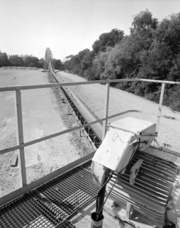 Transporteur automatique à bande et portique sur le canal, vus depuis l'installation de renvoi (3). © Région Bourgogne-Franche-Comté, Inventaire du patrimoine Transporteur automatique à bande et portique sur le canal, vus depuis l'installation de renvoi (3). © Région Bourgogne-Franche-Comté, Inventaire du patrimoine