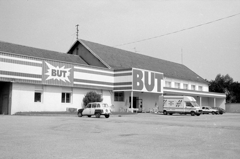 Magasin de commerce BUT (ancienne fonderie F2 et F3) vu de trois quarts gauche. © Région Bourgogne-Franche-Comté, Inventaire du patrimoine Magasin de commerce BUT (ancienne fonderie F2 et F3) vu de trois quarts gauche. © Région Bourgogne-Franche-Comté, Inventaire du patrimoine