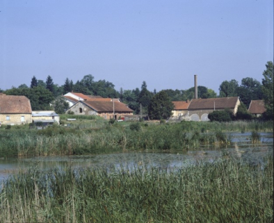 Vue de l'usine métallurgique depuis l'étang en 1989. © Région Bourgogne-Franche-Comté, Inventaire du patrimoine Vue de l'usine métallurgique depuis l'étang en 1989. © Région Bourgogne-Franche-Comté, Inventaire du patrimoine