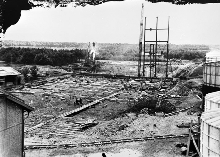 Construction de l'atelier de caustification : pose de la 1ère travée de l'ossature métallique, en 1930 (En arrière-plan à gauche, mouton à vapeur enfonçant un pilot) © Région Bourgogne-Franche-Comté, Inventaire du patrimoine Construction de l'atelier de caustification : pose de la 1ère travée de l'ossature métallique, en 1930 (En arrière-plan à gauche, mouton à vapeur enfonçant un pilot) © Région Bourgogne-Franche-Comté, Inventaire du patrimoine