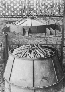 Fabrication de charbon de bois (ou de gaz carbonique ?) : mise en place du couvercle sur la machine. © Région Bourgogne-Franche-Comté, Inventaire du patrimoine Fabrication de charbon de bois (ou de gaz carbonique ?) : mise en place du couvercle sur la machine. © Région Bourgogne-Franche-Comté, Inventaire du patrimoine