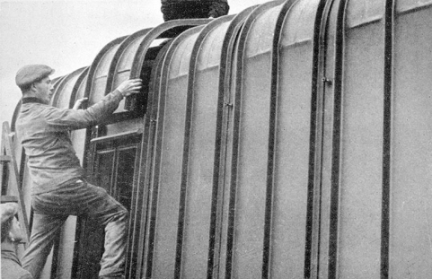 Montage d'un baraquement métallique dans les années 1940 : mise en place d'une tôle du toit. © Région Bourgogne-Franche-Comté, Inventaire du patrimoine