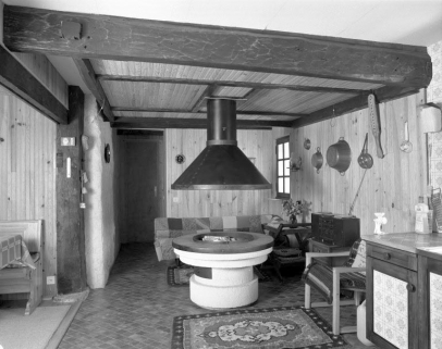 Le départ de la cheminée en bois au rez-de-chaussée. Sur la droite, accroché au mur, on aperçoit l'instrument en bois qui sert à l'ouverture des vantaux de la cheminée. © Région Bourgogne-Franche-Comté, Inventaire du patrimoine