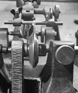 Molette (lame) d'une scie et diamant, vus de face.Pris entre deux mors, le diamant est au contact du disque en bronze phosphoreux, épais de 5 à 10 centièmes de mm. © Région Bourgogne-Franche-Comté, Inventaire du patrimoine