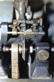 Molette (lame) d'une scie et diamant, vus de face.Pris entre deux mors, le diamant est au contact du disque en bronze phosphoreux, épais de 5 à 10 centièmes de mm. © Région Bourgogne-Franche-Comté, Inventaire du patrimoine