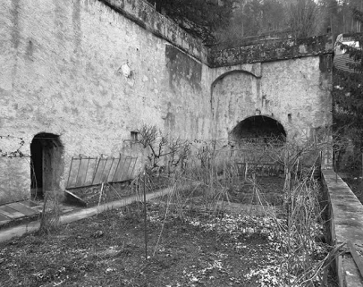 Mur de soubassement du jardin vu de trois quarts et abside de la chapelle Saint-Sébastien. © Région Bourgogne-Franche-Comté, Inventaire du patrimoine