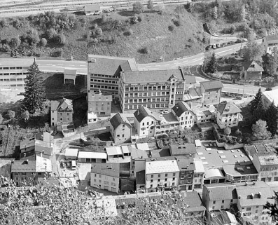 Anciennes usines de lunetterie Marius Morel (18 à 22 avenue Charles de Gaulle) et Cok et Cie (8 à 12 rue de la Paix). L'usine Cok était composée des deux maisons coiffées d'un toit en carène (au centre) et de l'atelier qui les réunit. © Région Bourgogne-Franche-Comté, Inventaire du patrimoine Anciennes usines de lunetterie Marius Morel (18 à 22 avenue Charles de Gaulle) et Cok et Cie (8 à 12 rue de la Paix). L'usine Cok était composée des deux maisons coiffées d'un toit en carène (au centre) et de l'atelier qui les réunit. © Région Bourgogne-Franche-Comté, Inventaire du patrimoine