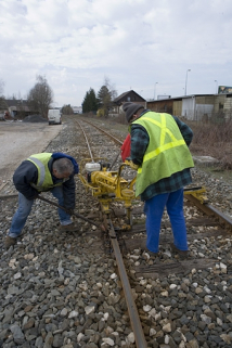 Utilisation par les agents de l'Equipement. L'agent de gauche bloque avec une masse métallique la tête du boulon, dont celui de droite visse l'écrou avec la tirefonneuse. © Région Bourgogne-Franche-Comté, Inventaire du patrimoine