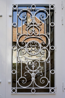 Détail de la ferronnerie de la porte d'entrée : bâtiment au fond de la cour. © Région Bourgogne-Franche-Comté, Inventaire du Patrimoine