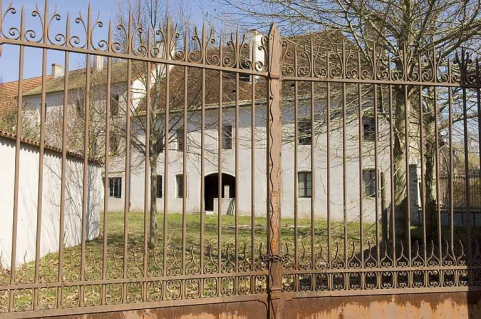 La cour vue à travers la grille d'entrée. © Région Bourgogne-Franche-Comté, Inventaire du patrimoine