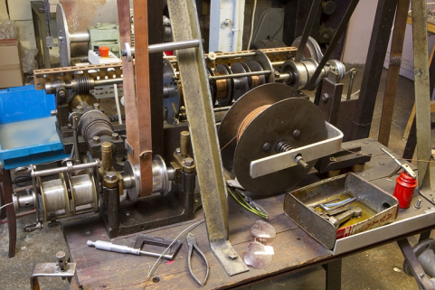 Le module de cordage avec les fils de nickel. Le fil cordé, issu du premier module de cordage (à l'arrière-plan) et enroulé sur la bobine à droite, sort de la machine à gauche revêtu de nickel. © Région Bourgogne-Franche-Comté, Inventaire du patrimoine