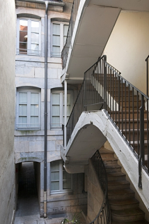 Escalier à cage ouverte situé dans la première cour : vue des volées supérieures. © Région Bourgogne-Franche-Comté, Inventaire du Patrimoine