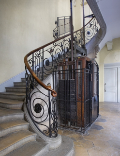 Aile droite : détail du départ de l'escalier et de l'ascenseur, vue éloignée de trois quart gauche. © Région Bourgogne-Franche-Comté, Inventaire du Patrimoine