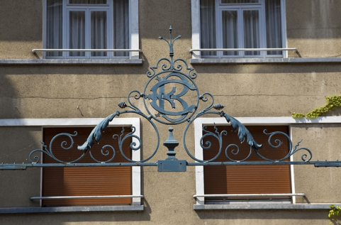 Détail du couronnement du portail de la grille en fer forgé séparant les deux cours. © Région Bourgogne-Franche-Comté, Inventaire du Patrimoine