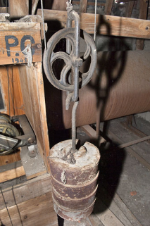 Un des poids actionnant les filins et l'une des inscriptions peintes sur la caisse. © Région Bourgogne-Franche-Comté, Inventaire du patrimoine