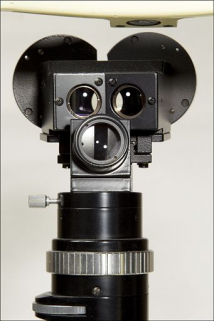 Détail de la partie optique, vue du côté du patient : objectifs et partie arrière de la binoculaire en haut, module d'éclairage et son objectif en bas. © Région Bourgogne-Franche-Comté, Inventaire du patrimoine