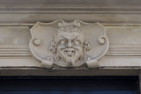 Façade antérieure, vue rapprochée d'un mascaron sur la porte d'entrée du magasin. © Région Bourgogne-Franche-Comté, Inventaire du Patrimoine