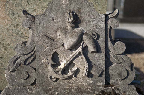 Tombeau précédent. Détail : panneau au pied de la croix représentant un relief composé d'une croix, d'une ancre et d'un coeur enflammé. © Région Bourgogne-Franche-Comté, Inventaire du patrimoine
