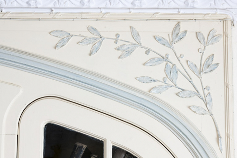 Décor du salon : branche de laurier au-dessus de la porte ouvrant sur le vestibule. © Région Bourgogne-Franche-Comté, Inventaire du patrimoine