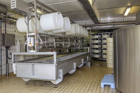 Installation de soutirage par pompe à caillé : le répartiteur. Les rehausses de moulage sont suspendues en partie haute du répartiteur. © Région Bourgogne-Franche-Comté, Inventaire du patrimoine