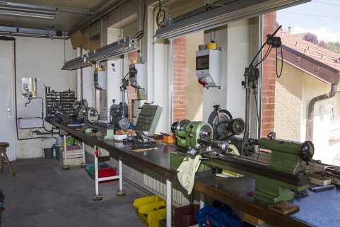 Usine, rez-de-chaussée : établi à l'arrière des fenêtres, supportant des tours. © Région Bourgogne-Franche-Comté, Inventaire du patrimoine Usine, rez-de-chaussée : établi à l'arrière des fenêtres, supportant des tours. © Région Bourgogne-Franche-Comté, Inventaire du patrimoine