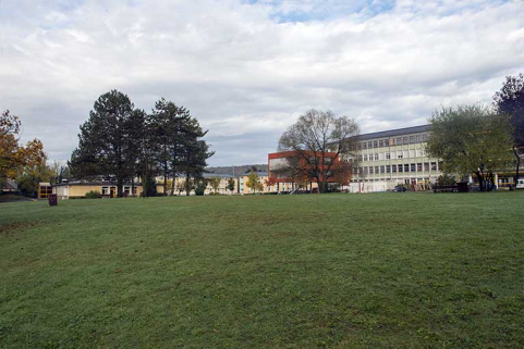 Grande cour centrale engazonnée face à la cantine et part ouest de l'externat des cours généraux et du centre de documentation et d'information et pignon sud du pôle scientifique. © Région Bourgogne-Franche-Comté, Inventaire du patrimoine
