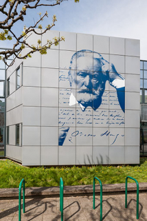 Donnant sur la place devant le lycée, la façade sud-est décorée à l'effigie de Victor Hugo. © Région Bourgogne-Franche-Comté, Inventaire du patrimoine